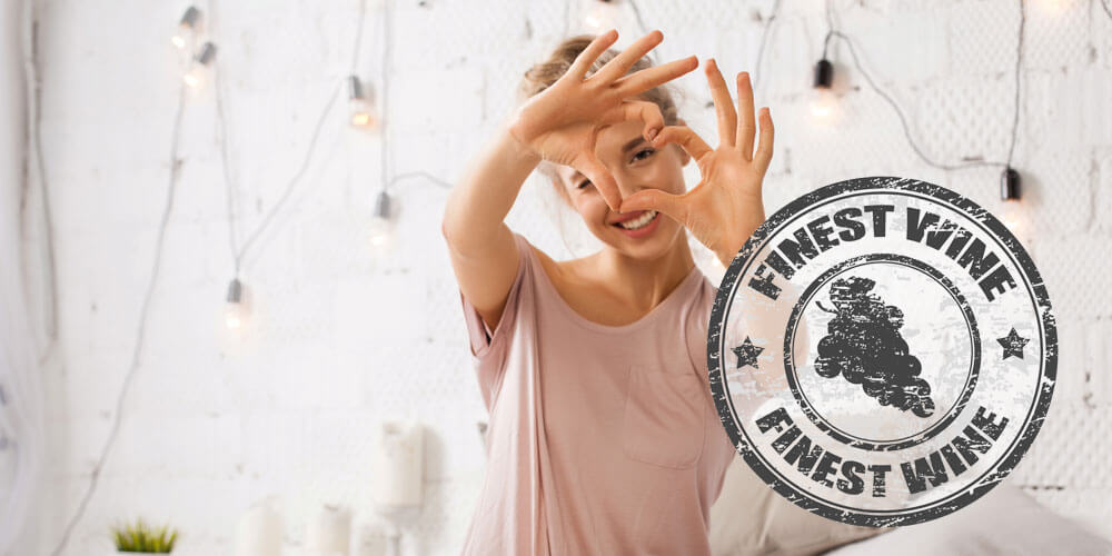 Frau formt mit Ihren Händen ein Herz, daneben ist ein Stempel mit einer Weinrebe und der Aufschrift "Finest Wine" sichtbar